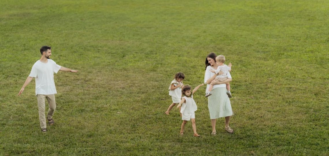 A joyful family enjoying a sunny day outdoors in a green park.