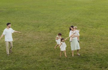 A joyful family enjoying a sunny day outdoors in a green park.